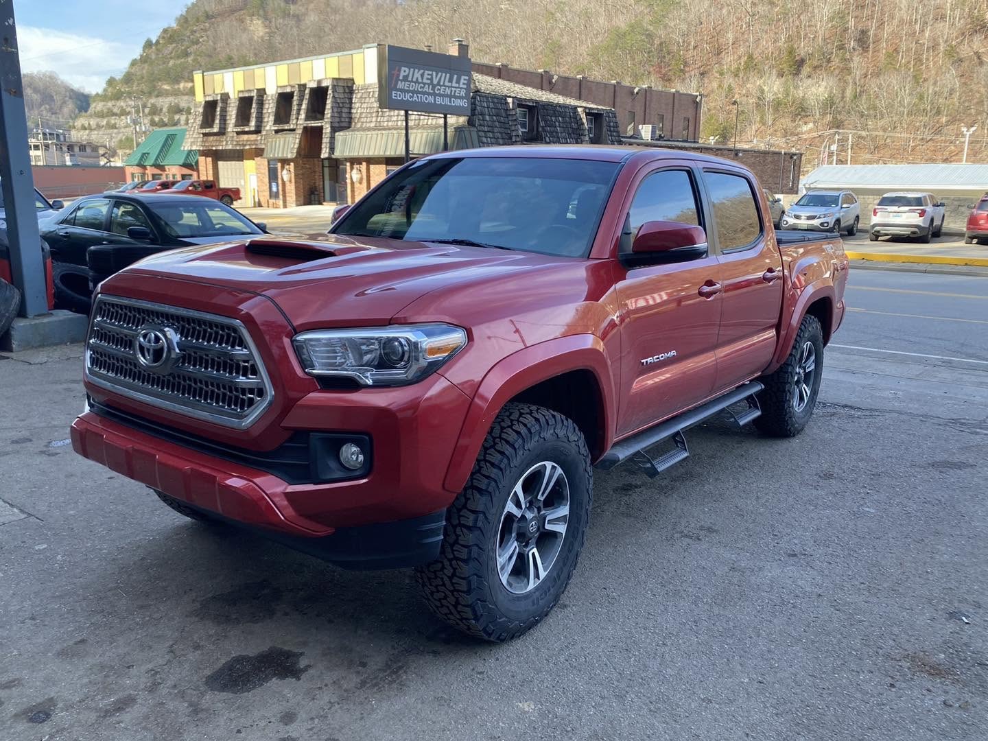 Lifted red Toyota Tacoma TRD on all-terrain tires in Pikeville